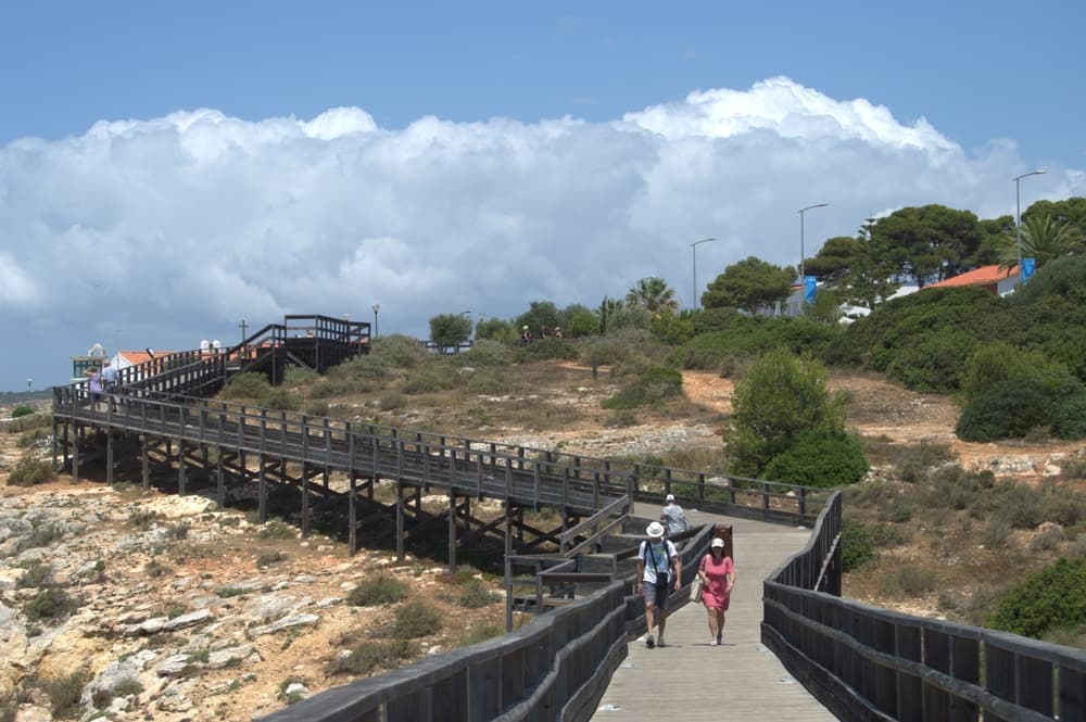 Beachfront boardwalk stretches into the distance, Carvoeiro
