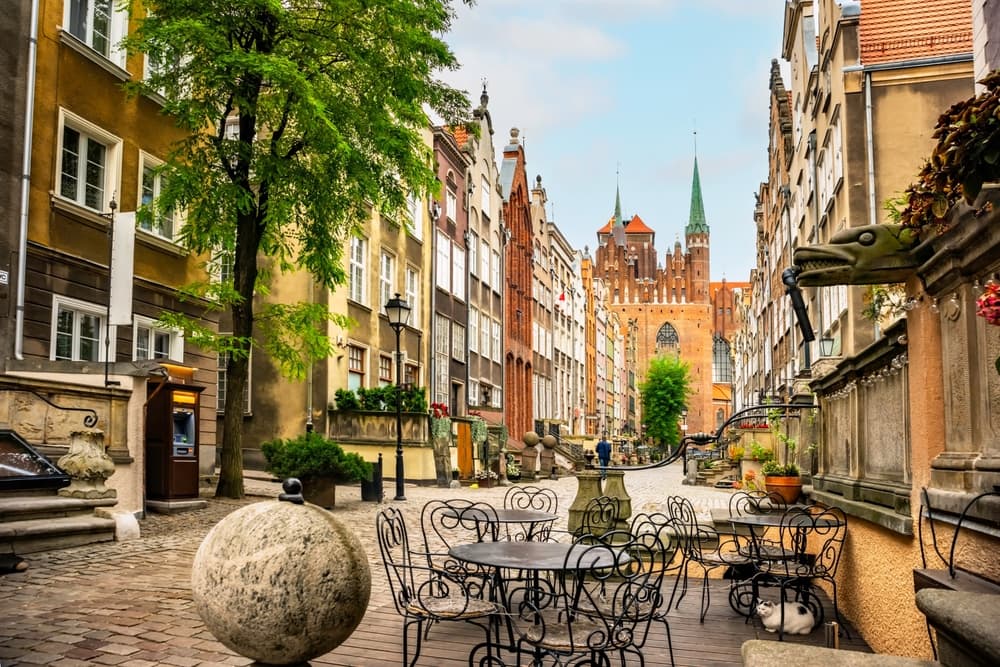 Architecture on Mariacka St beside cafe chairs, Gdańsk