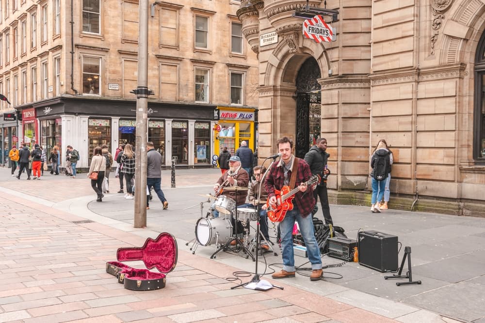 UK buskers play guitar and drums while singing, Glasgow