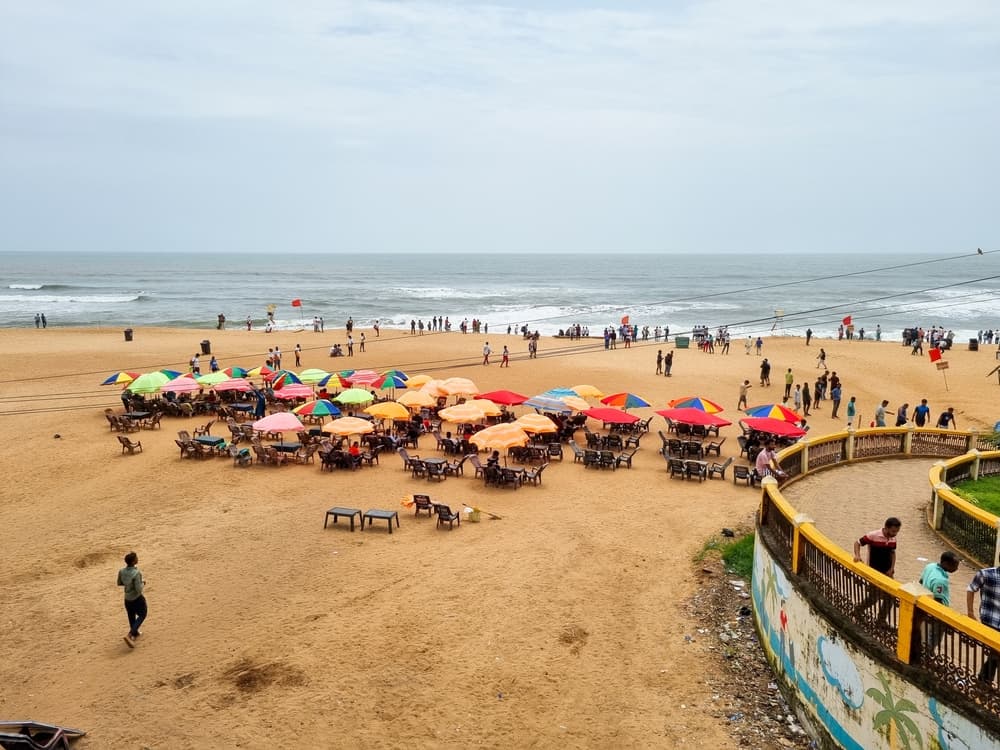 Cluster of umbrellas shade beachgoers from sun, Goa