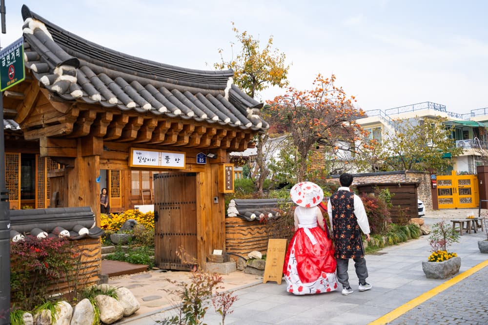 Couple in traditional dress stroll through Hanok village, Jeonju