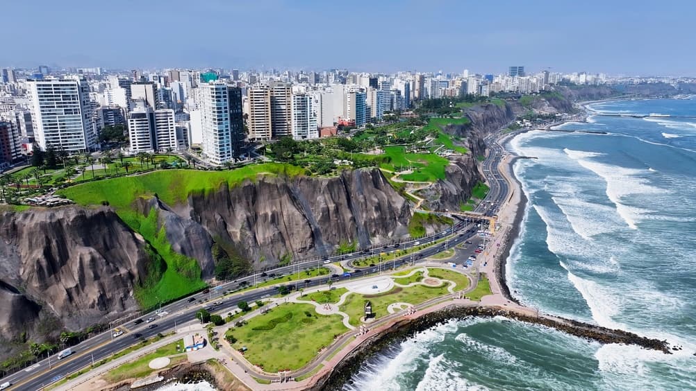 Aerial of the Miraflores skyline on cliff above coast, Lima