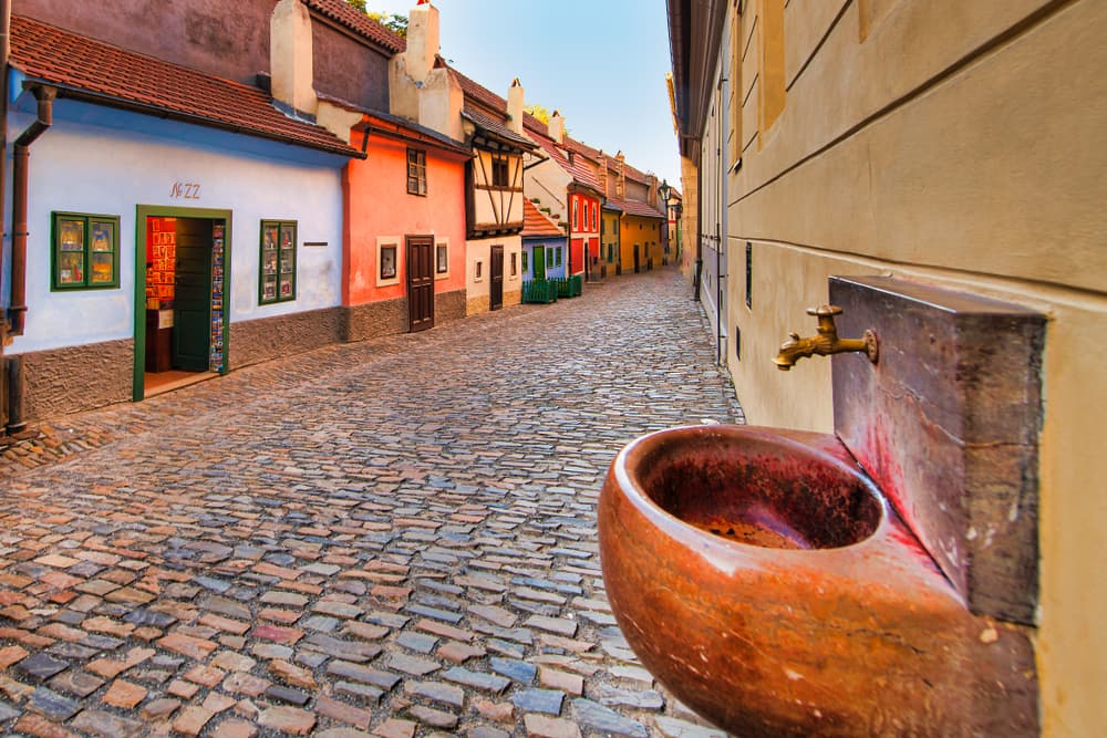 Cobblestone street runs alongside small homes, Plzeň