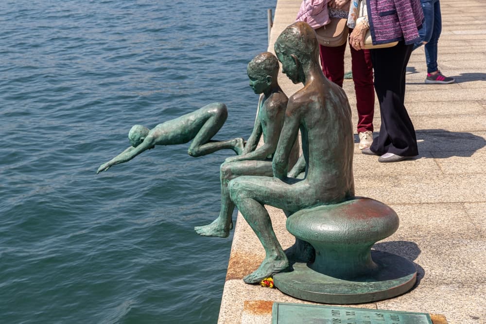 Bronze statues diving off the sidebar into ocean, Santander