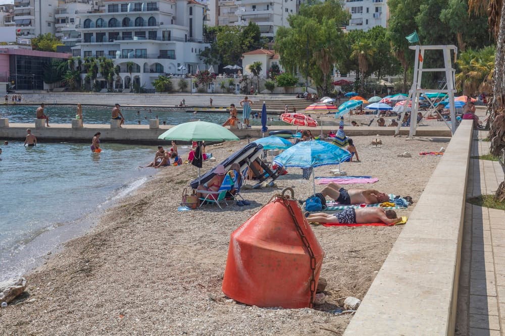Locals and tourists lounging on beach during summer, Sarandë