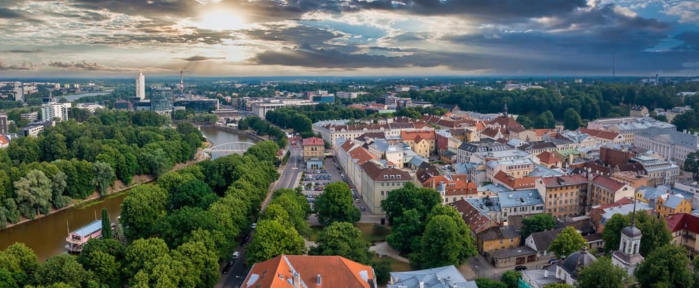 Cityscape with train moving along riverside, Tartu