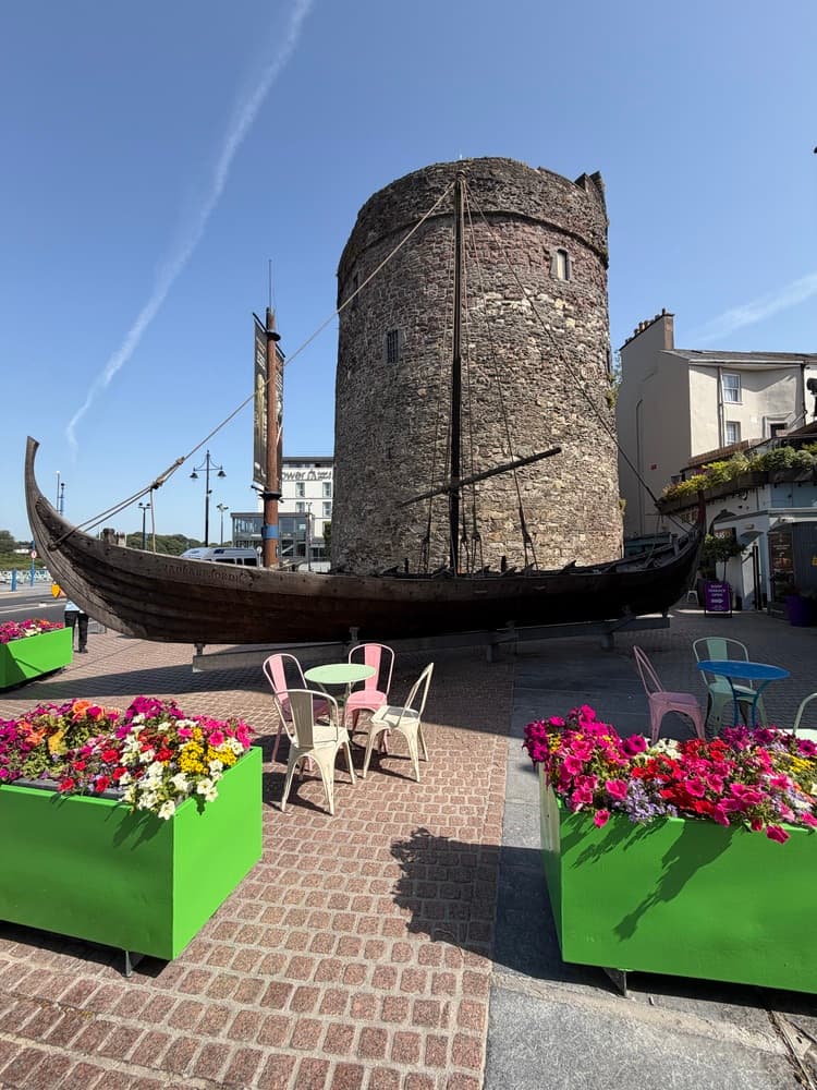 Aged sailing ship in front of stone tower, Waterford