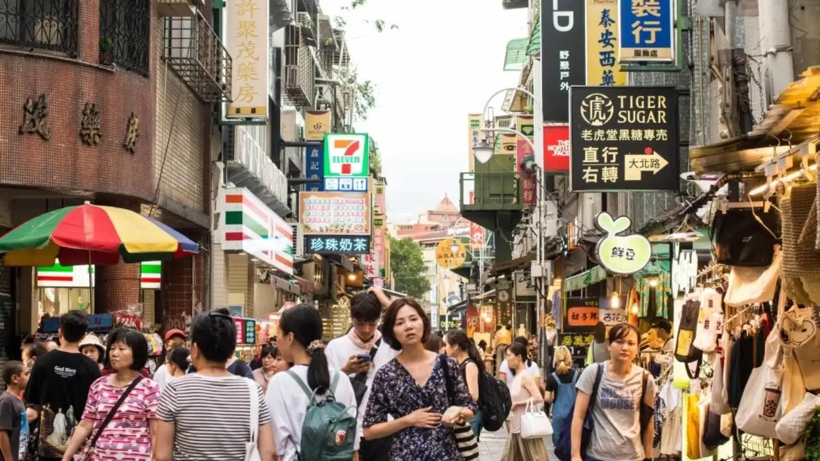Students walking past shops on a busy pedestrian street in Taiwan