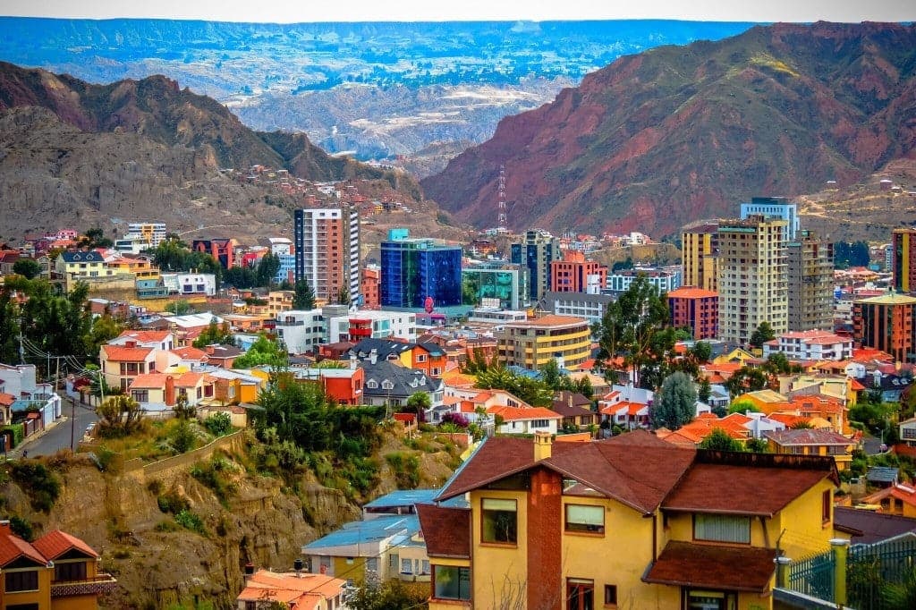Colorful houses and apartment towers of Zona Sur in La Paz below red Andean hills