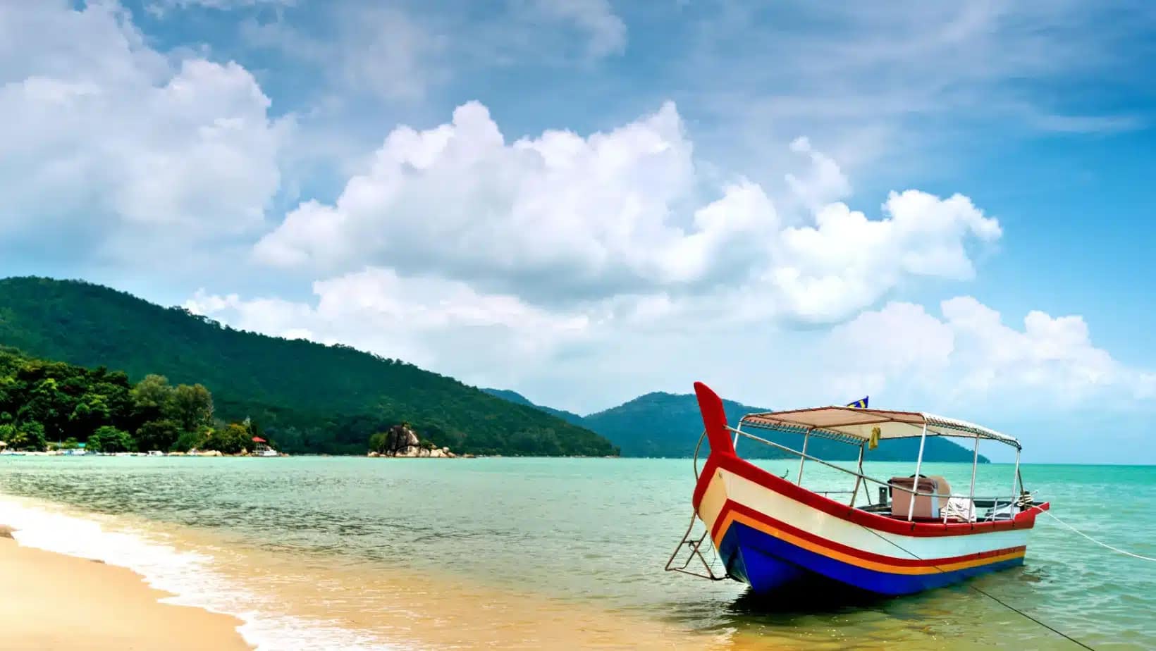 A painted fishing boat on a beach in Penang, Malaysia