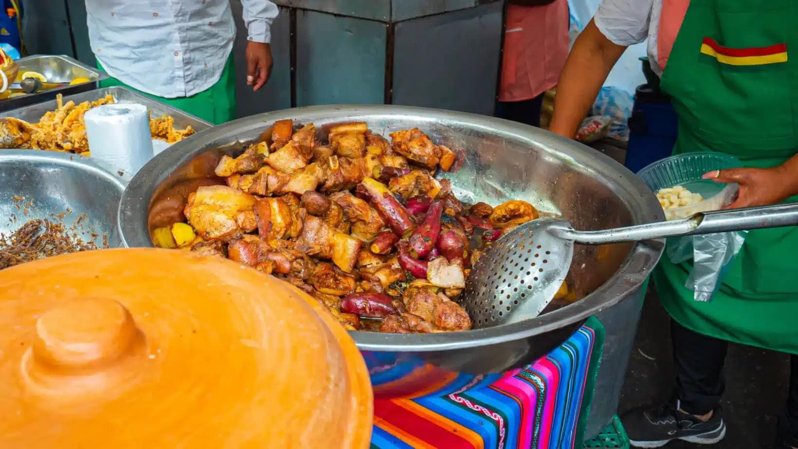 A market stall in Bolivia serving a big pan of spicy stewed chicken and potatoes