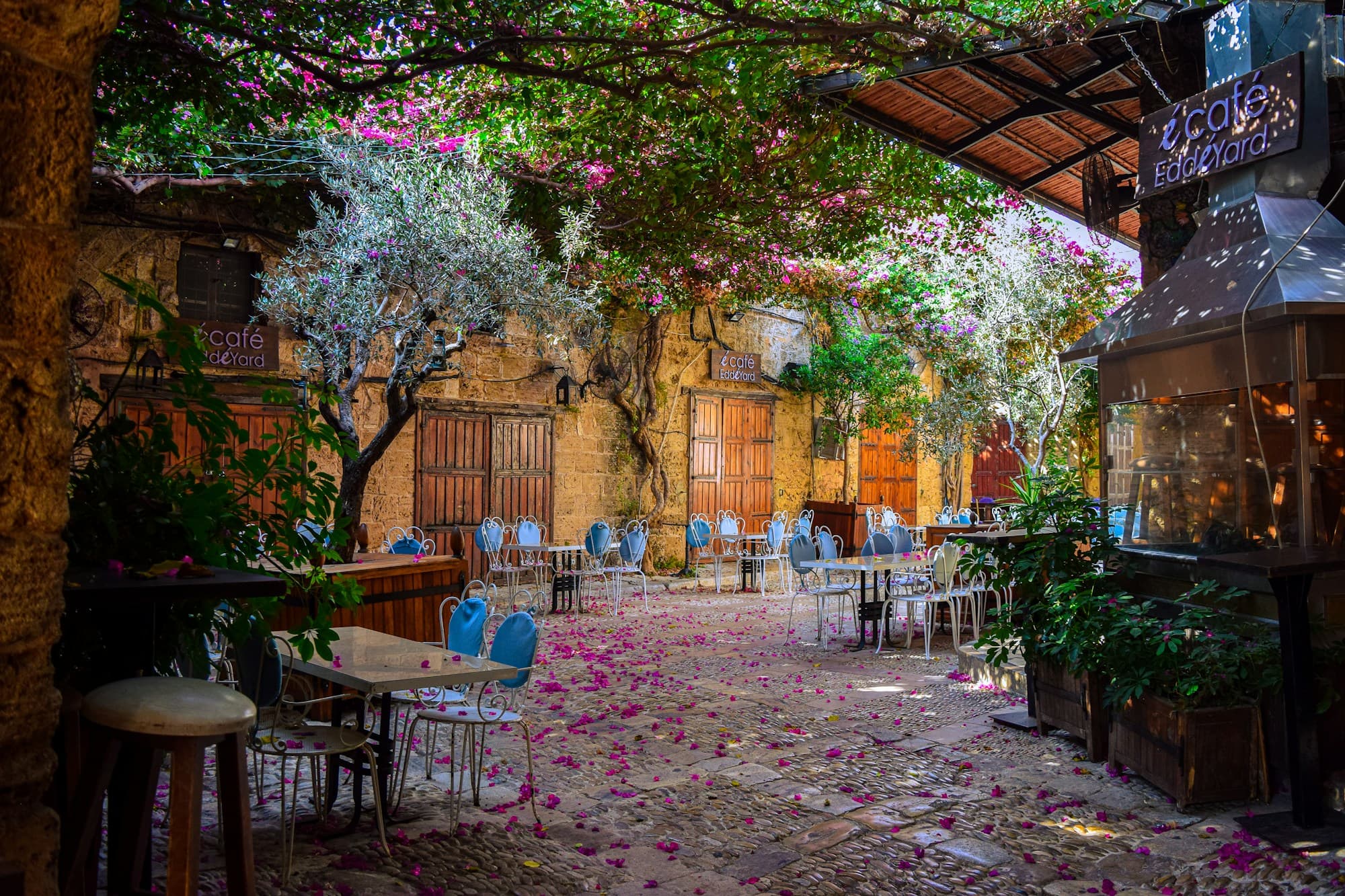 A stone courtyard café under bougainvillea in the old souk of Byblos