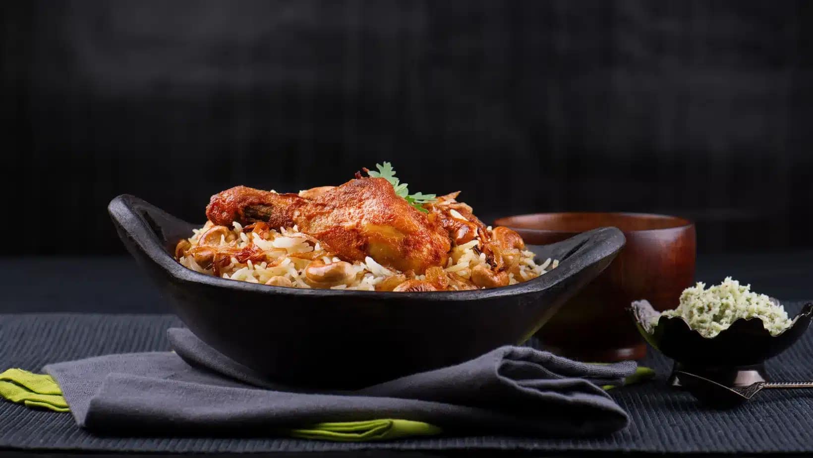 A bowl of chicken biryani served in a black dish