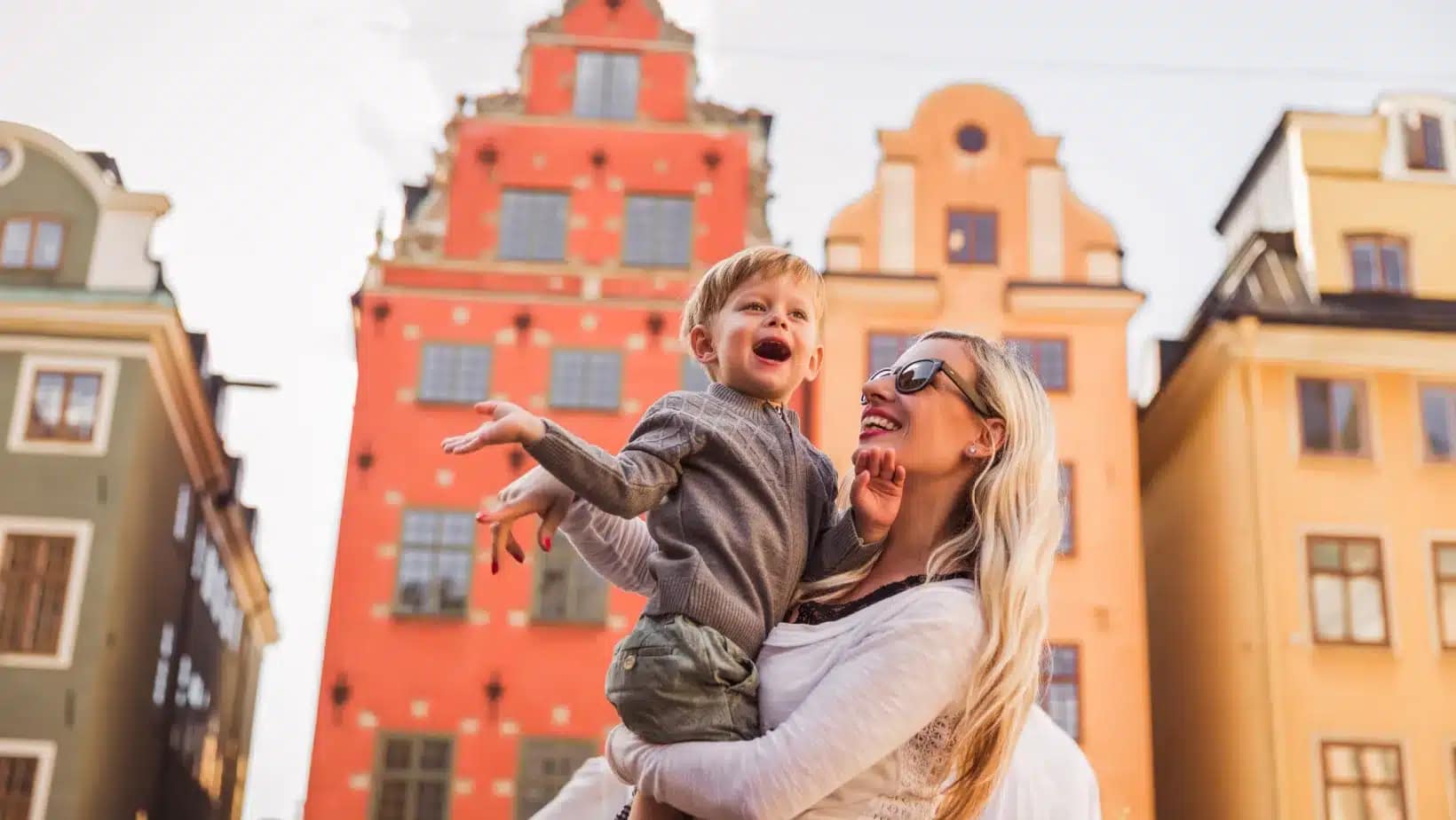 A mother lifting her young son in Stortorget square in Stockholm's old town