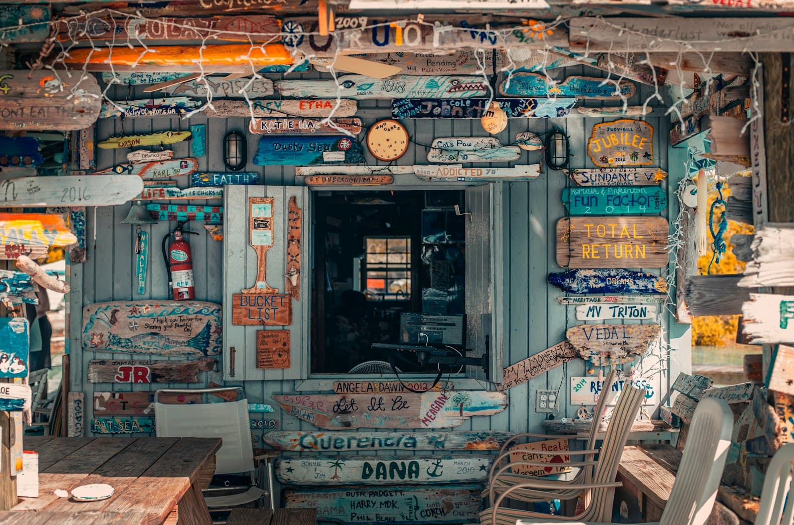 A dockside bar wall covered in hand-painted boat name signs from visiting sailors