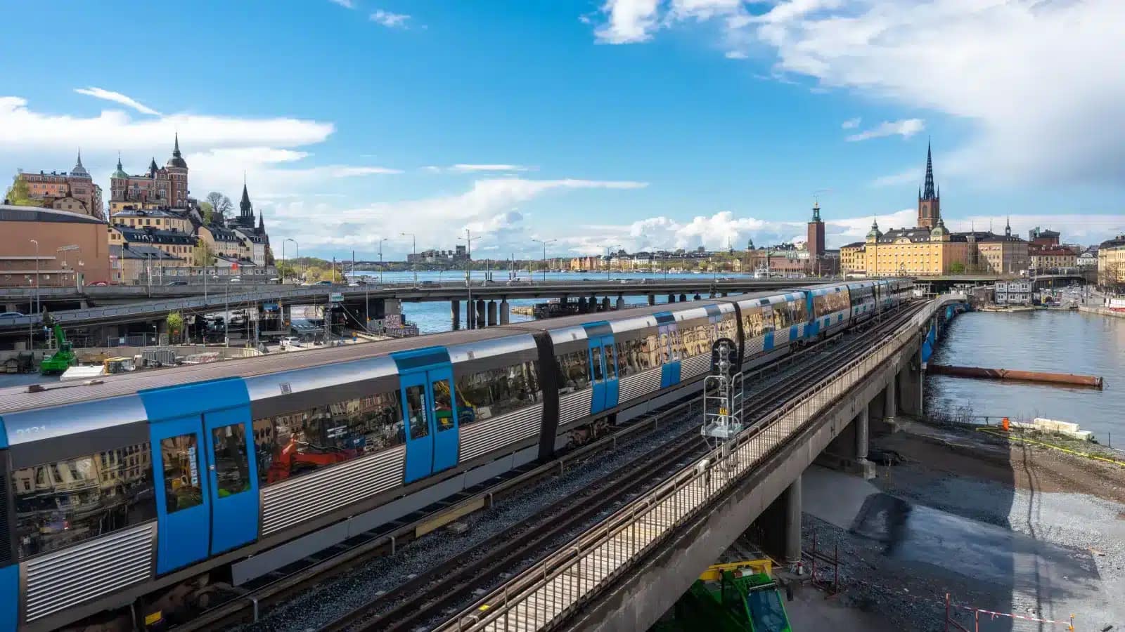 A blue commuter train crossing a bridge in central Stockholm