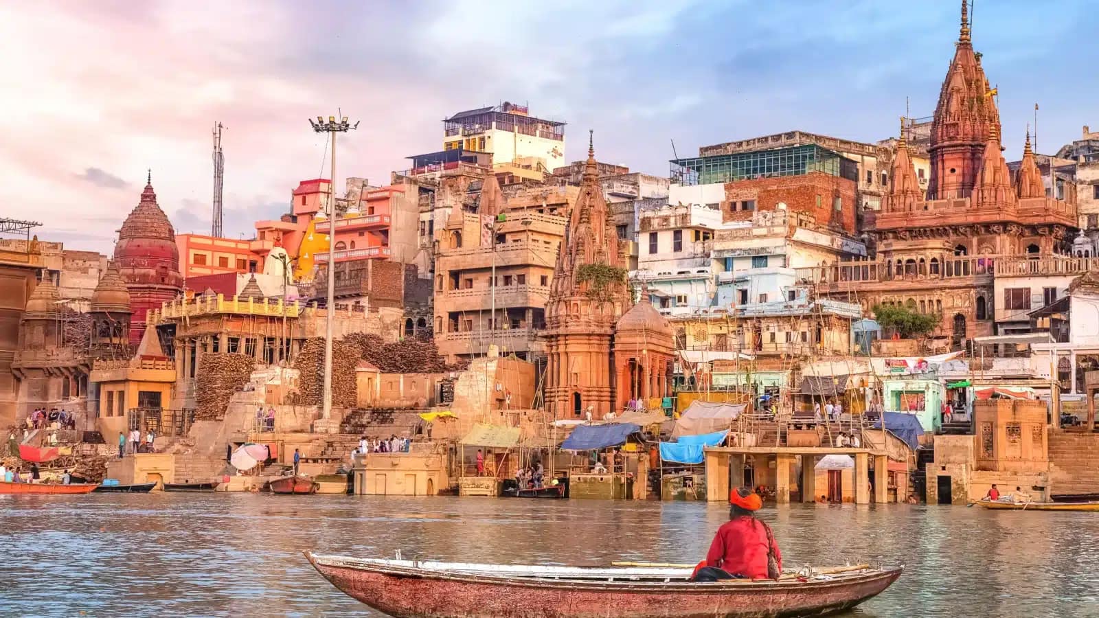 A boatman on the Ganges in front of the ghats of Varanasi at sunset