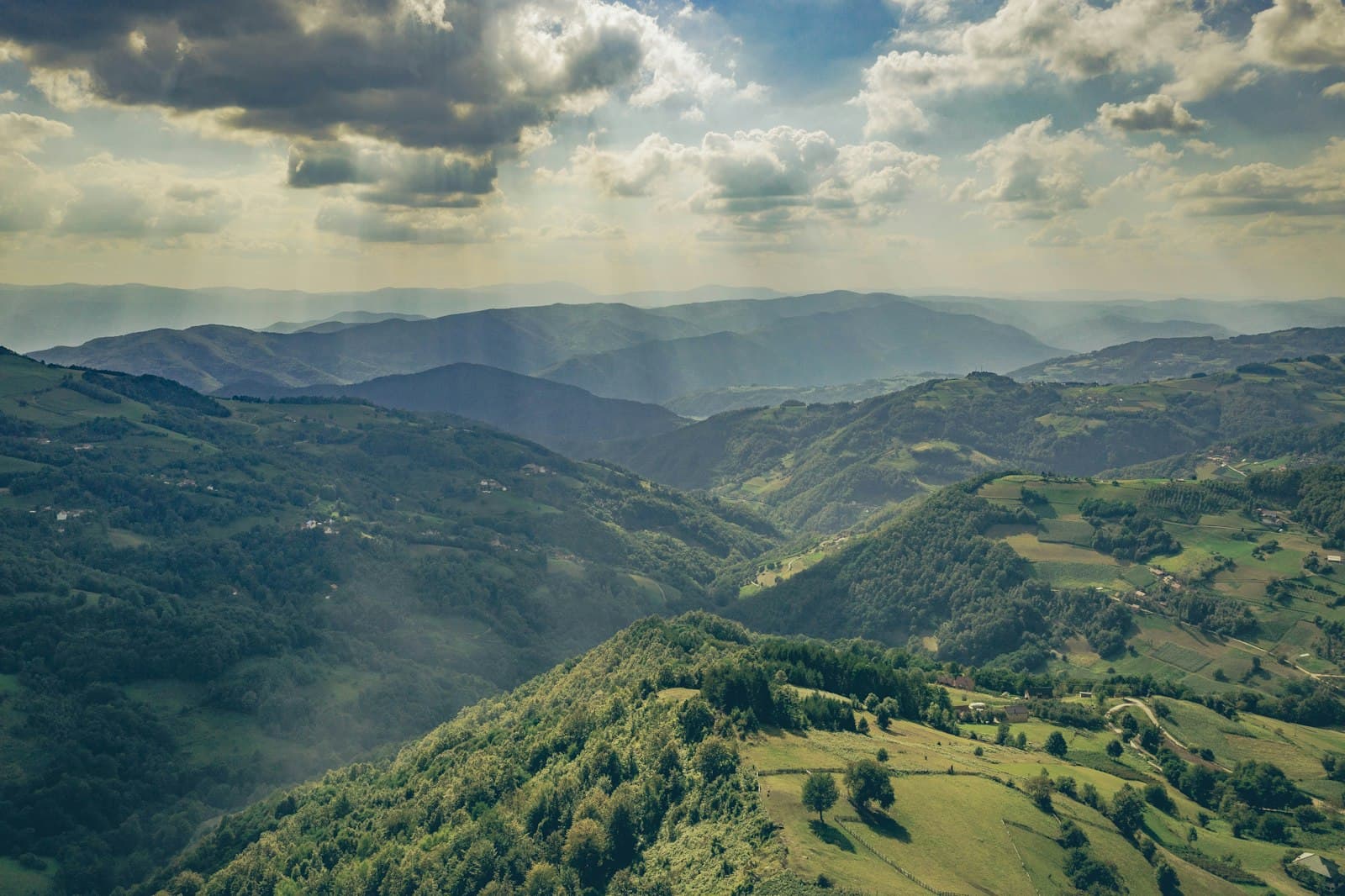 Rolling green hills and scattered farms in the Serbian countryside