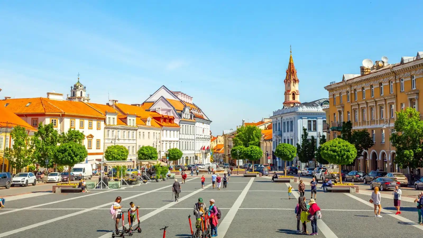 Town Hall Square in Vilnius Old Town on a sunny day, with pastel buildings and a church spire