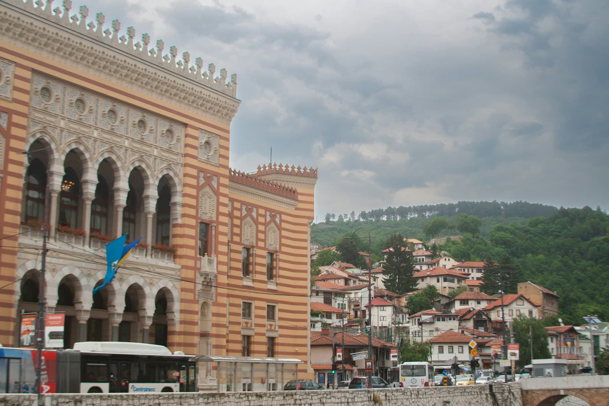 Sarajevo City Hall, a striped Moorish-revival building, with hillside houses behind it