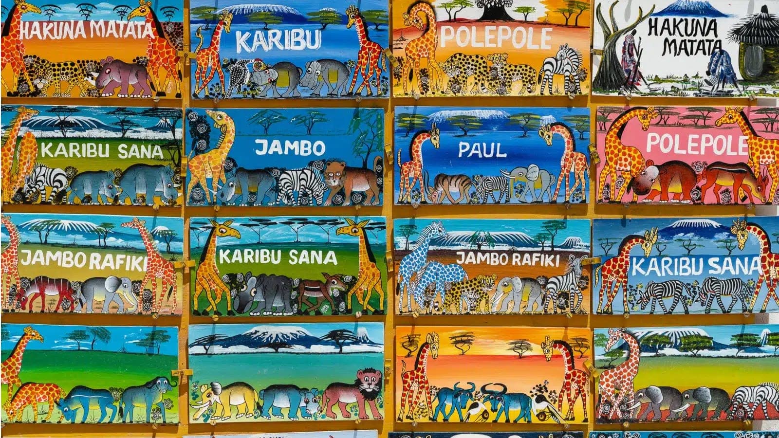 Hand-painted Swahili greeting signs for sale at a Kenyan craft stall