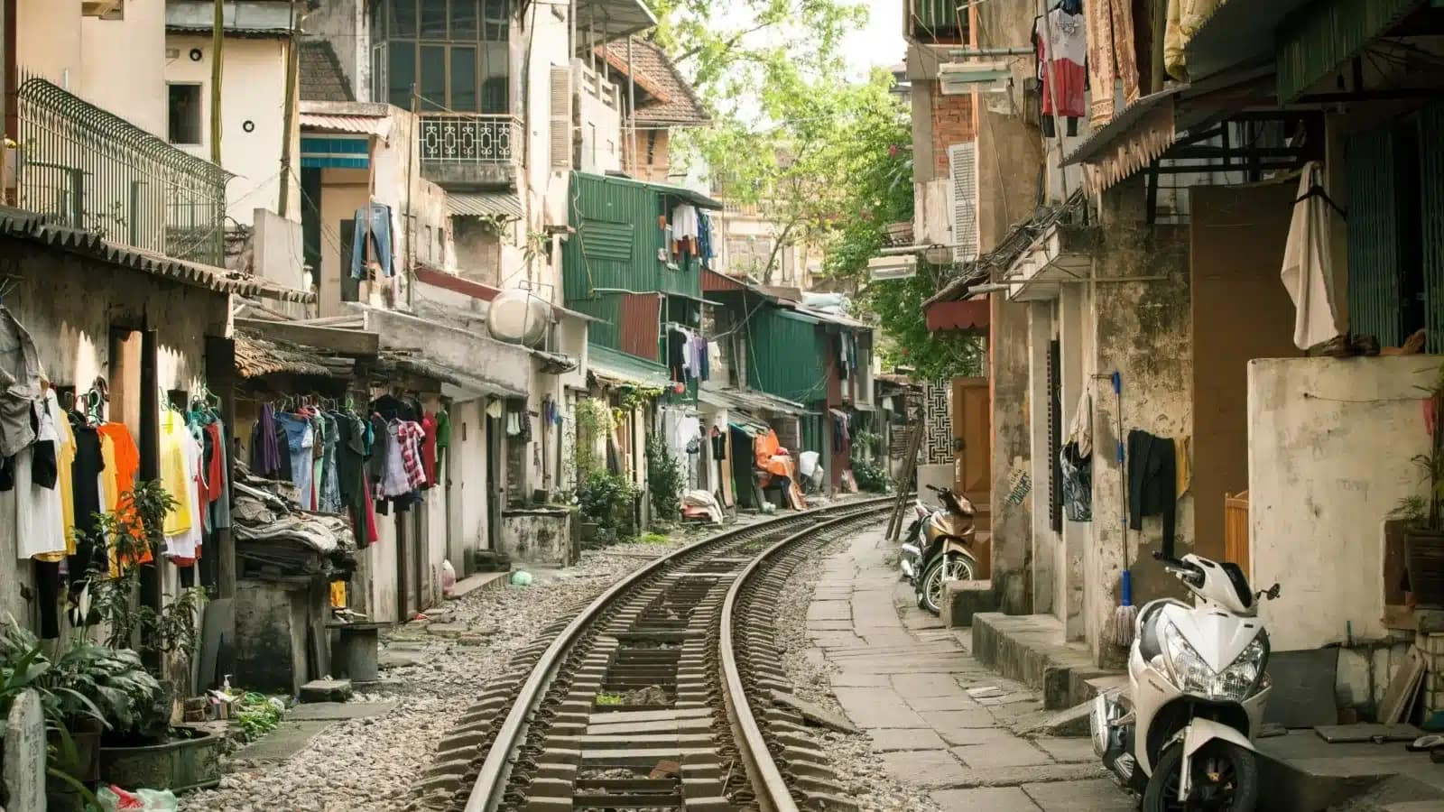 Hanoi's train street, with rail tracks running between narrow houses and parked scooters