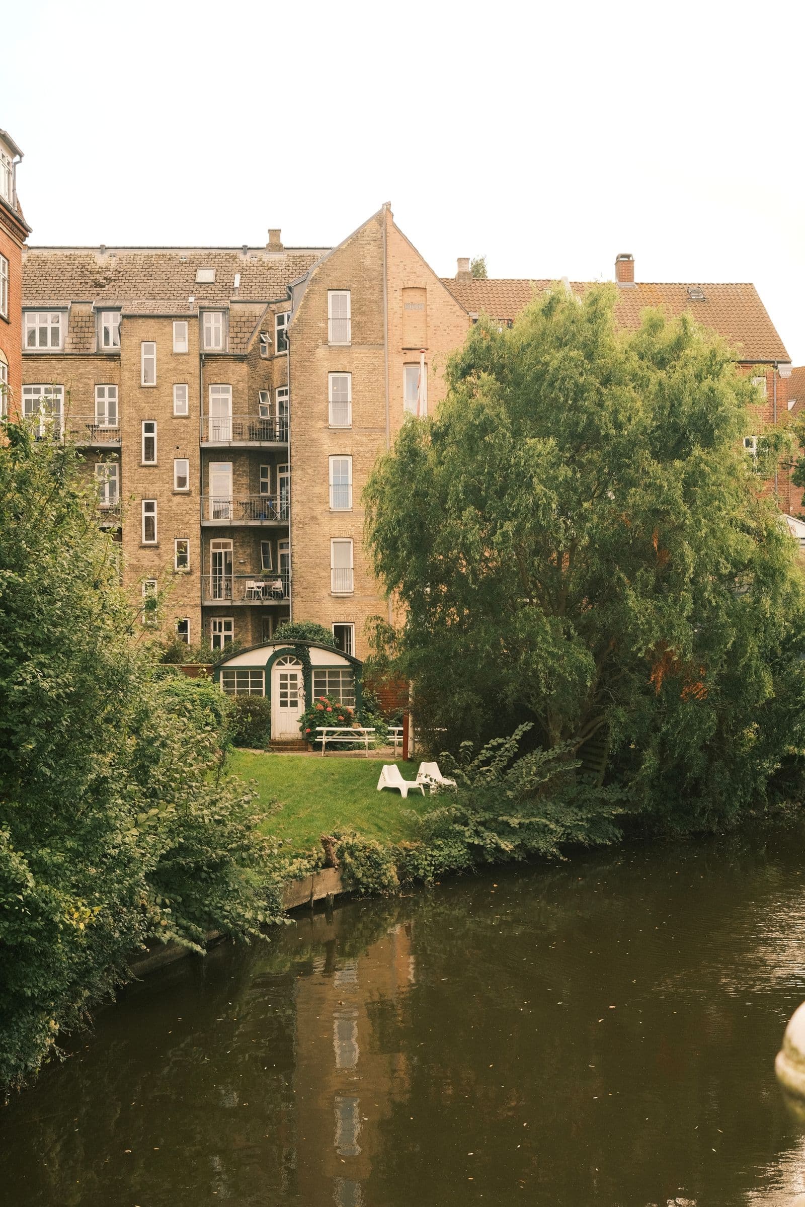 Brick apartment building with a garden beside the river in Aarhus, Denmark