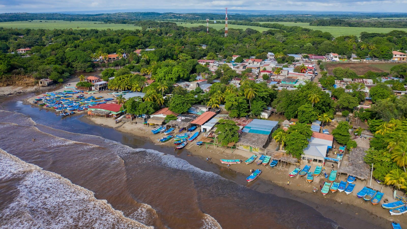 Aerial view of a Nicaraguan Pacific fishing village with colorful boats on the beach