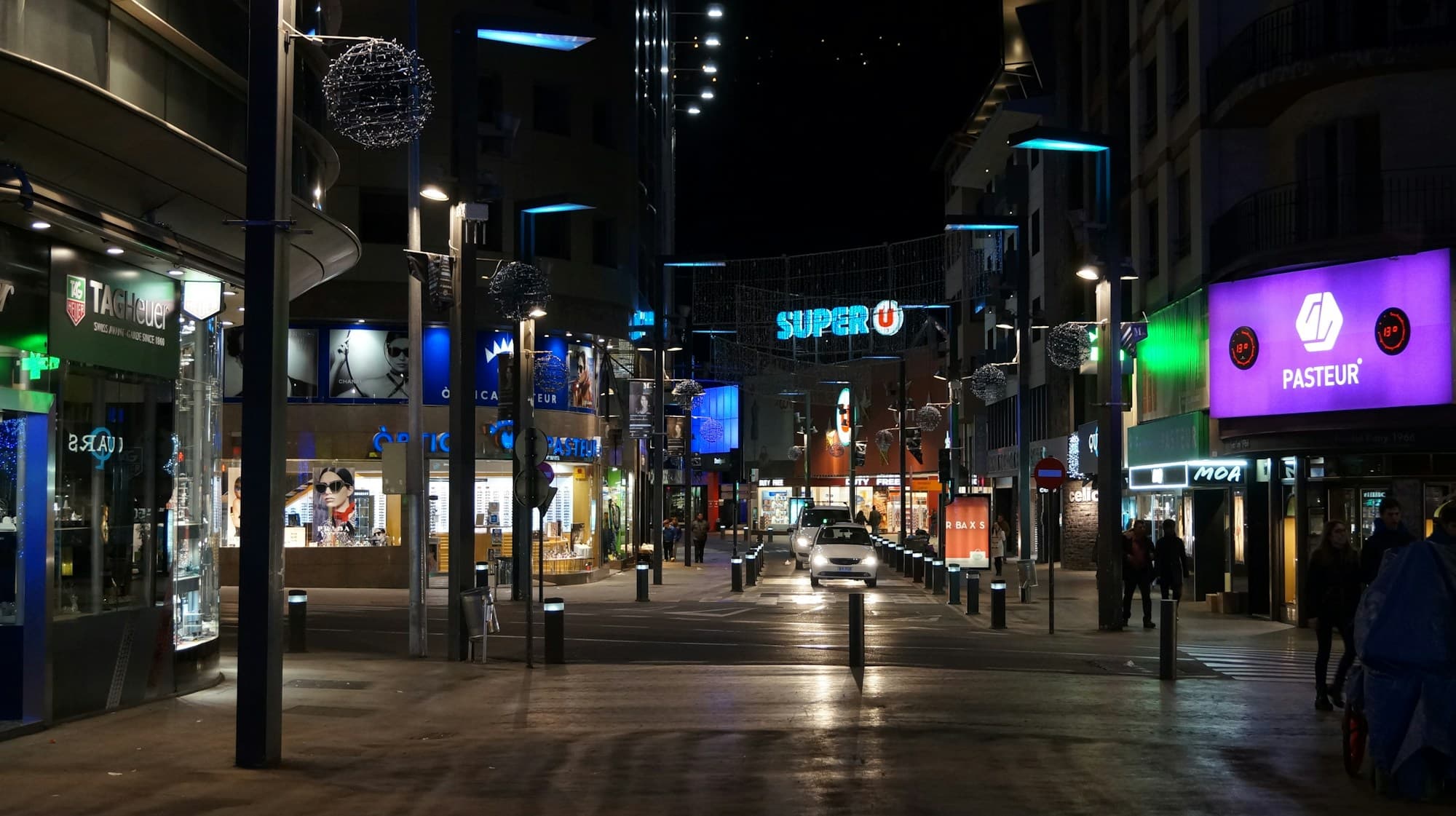 A pedestrian shopping street in Andorra la Vella lit up at night