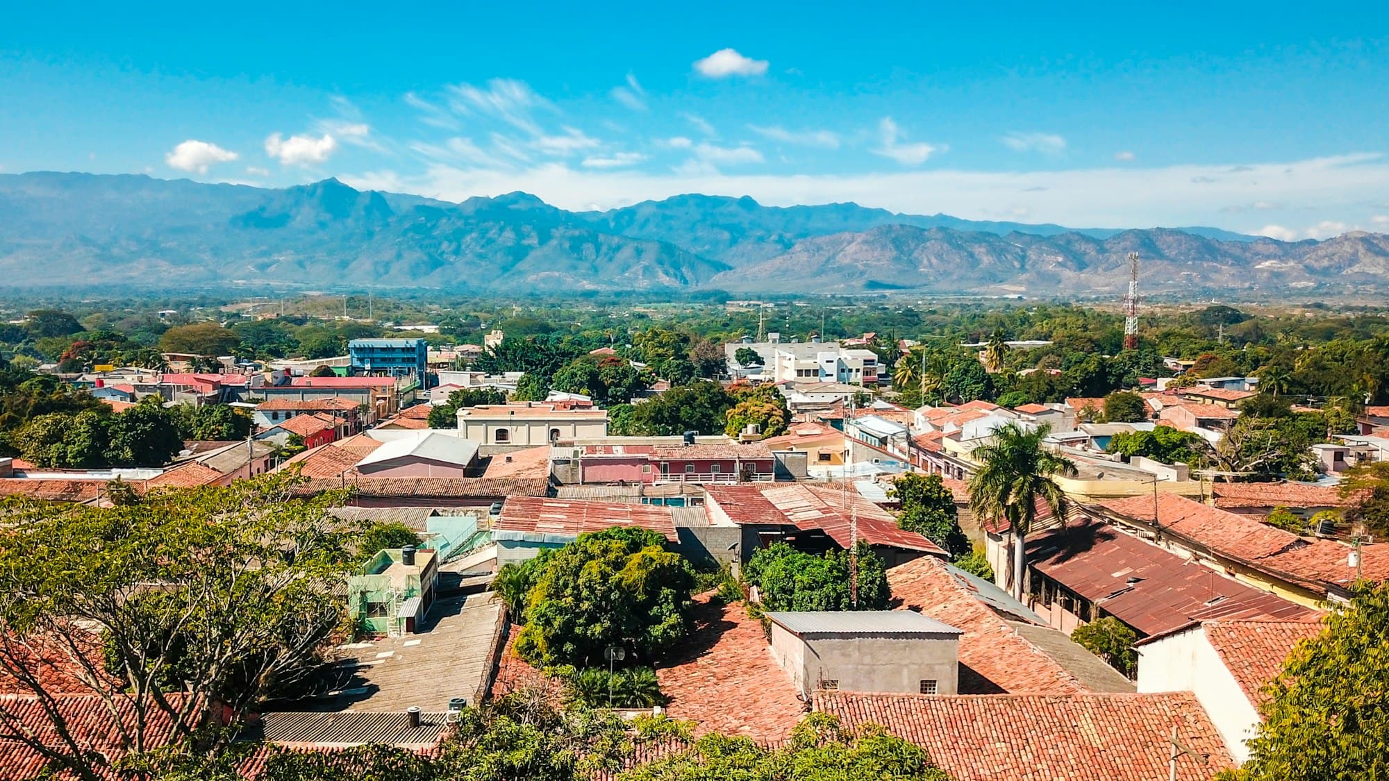 Red tile roofs of a Honduran town with mountains on the horizon