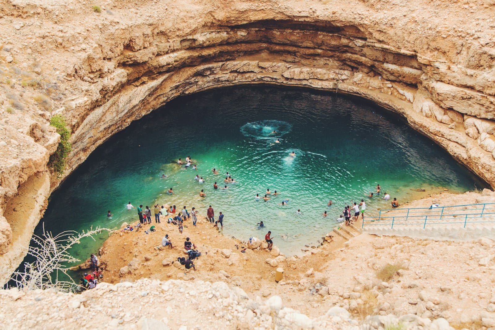 Swimmers in the turquoise Bimmah Sinkhole on Oman's coast