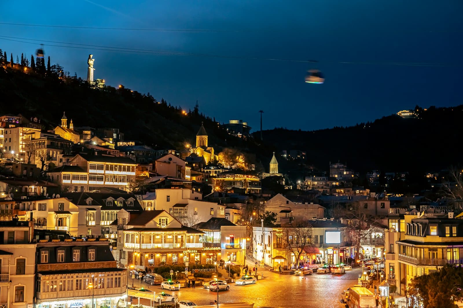 Tbilisi's old town at night, with lit balconies and churches climbing the hillside