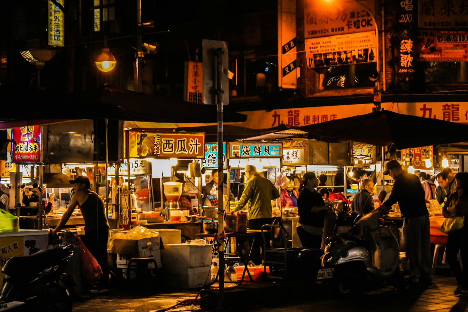 Food stalls lit up at a busy Taiwanese night market