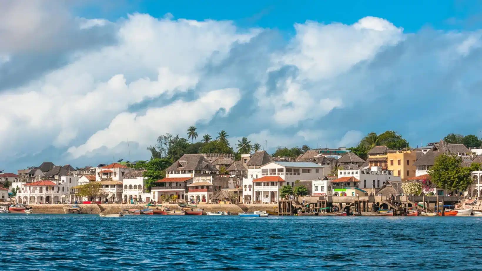 Whitewashed waterfront houses and dhows along the harbor in Lamu, Kenya