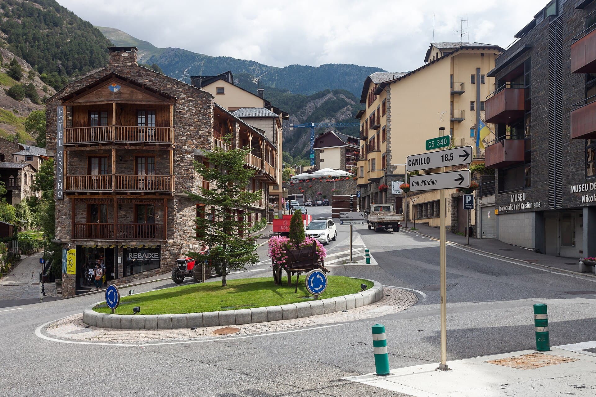Stone and timber buildings around a small roundabout in the center of Ordino, Andorra