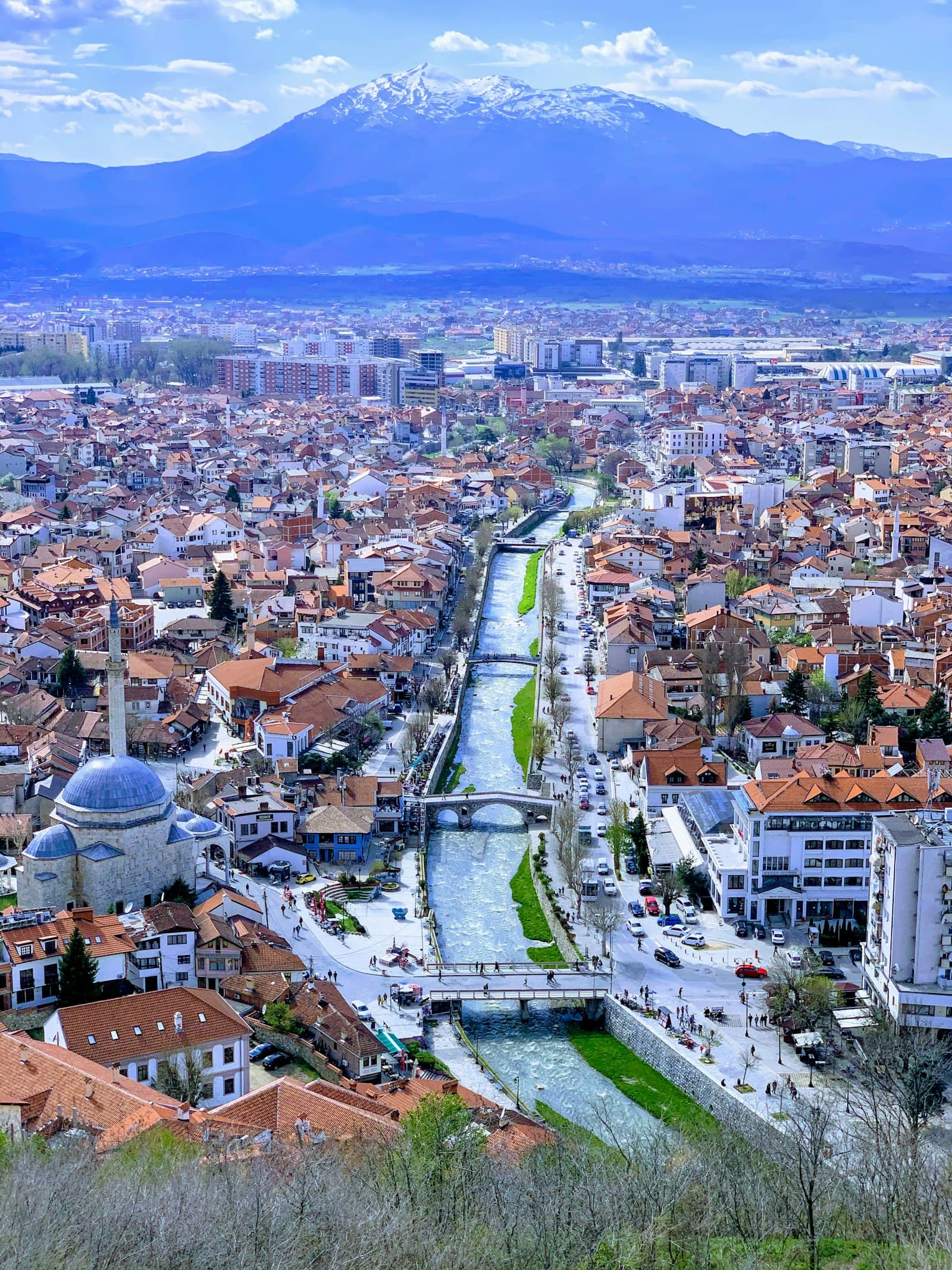 View over Prizren's old town, river and mosque dome toward snow-capped mountains