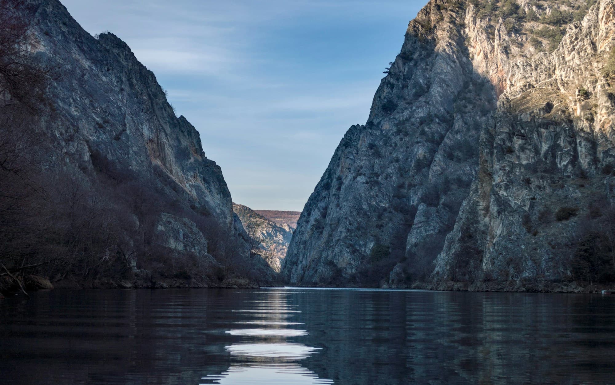 Still water between steep limestone cliffs in a river canyon in North Macedonia
