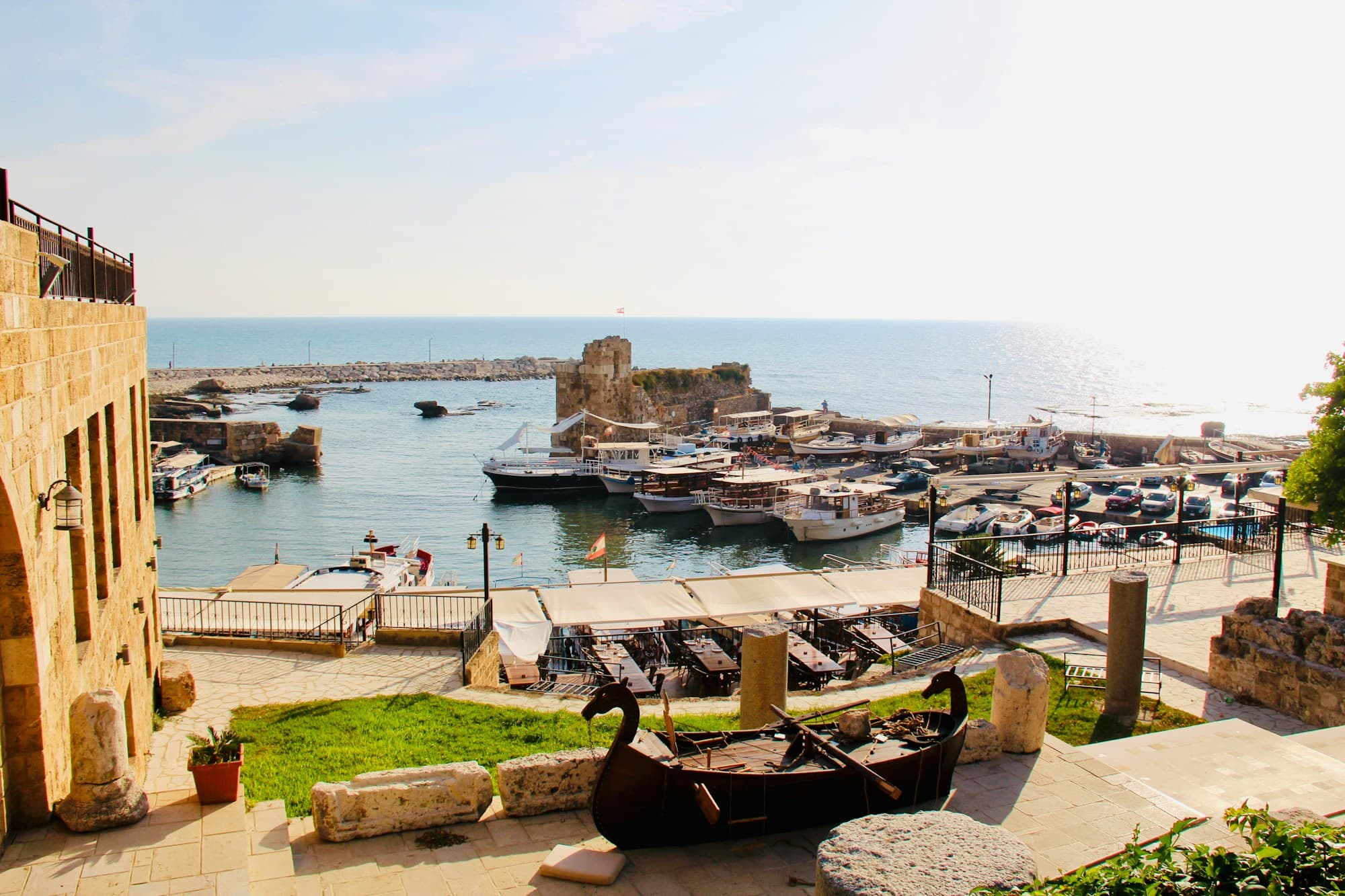 Fishing boats in the old harbor of Byblos beside a medieval stone tower