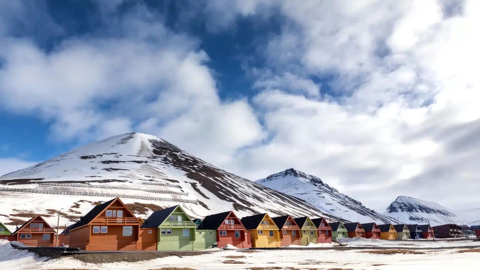 Colorful wooden houses below snowy mountains in Longyearbyen, Svalbard