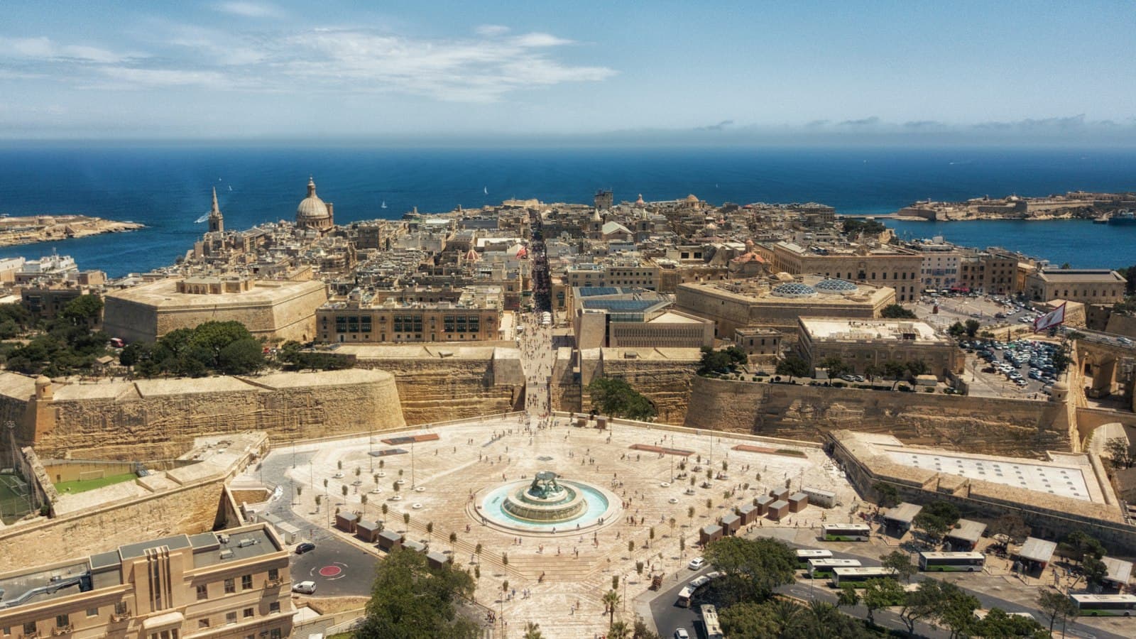 Aerial view of Valletta's City Gate, Triton Fountain and the Grand Harbour beyond