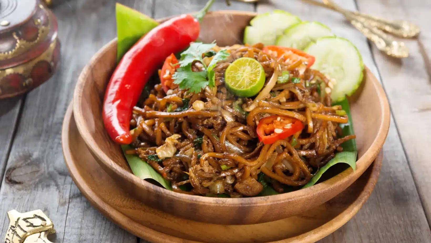 A plate of Malaysian mi goreng fried noodles with chili and lime