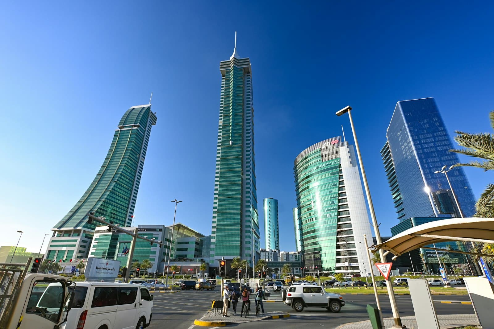 Glass towers of Bahrain Financial Harbour above a busy Manama street on a clear day