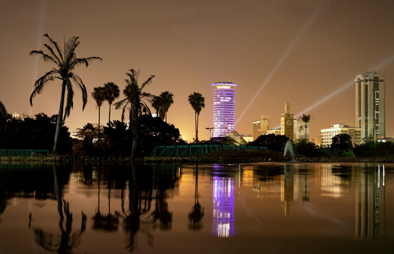 Nairobi's Kenyatta International Convention Centre lit up at night, reflected in a pond