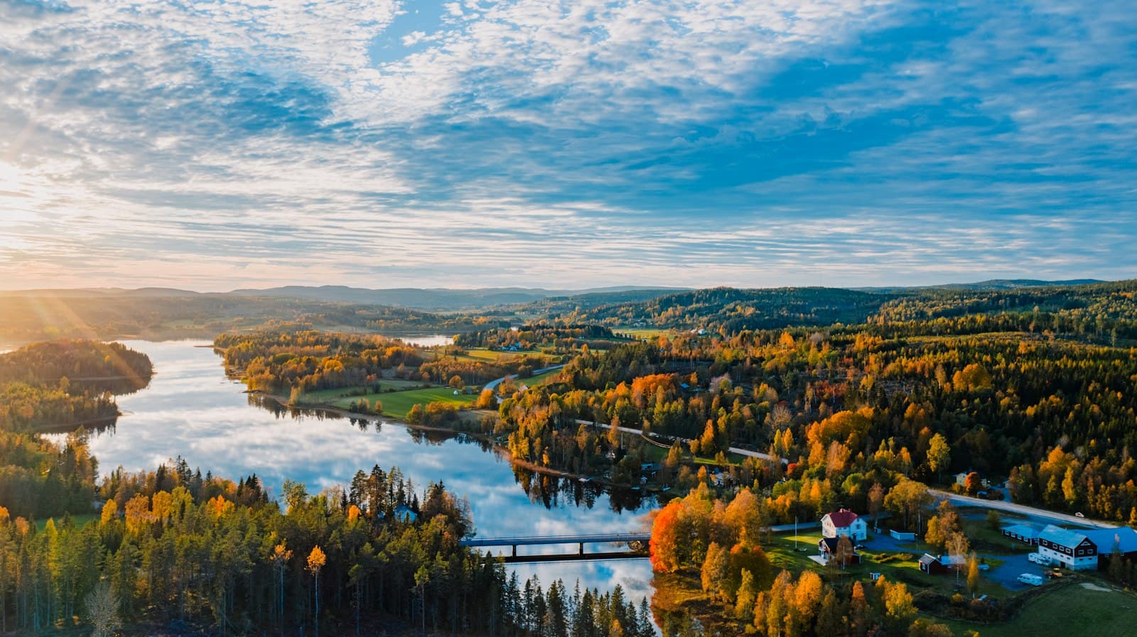 Aerial view of a lake winding through autumn forest in Sweden