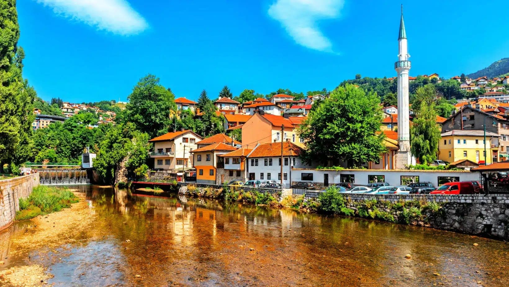 Houses and a minaret along the river in Sarajevo