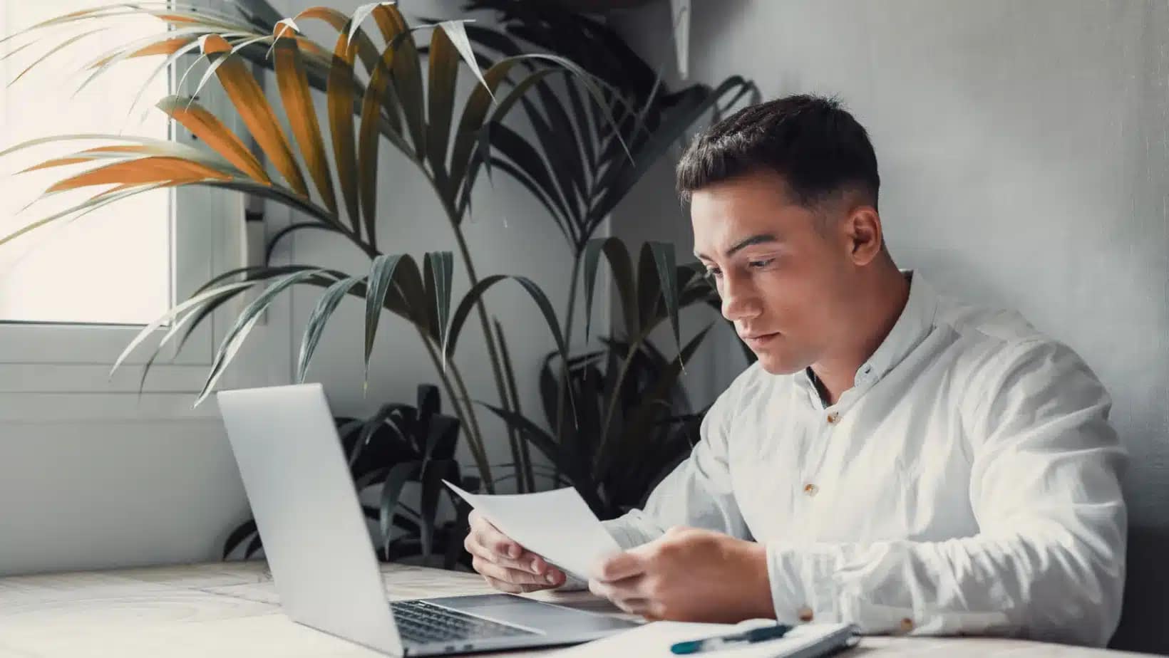 Student reviewing application paperwork at a laptop
