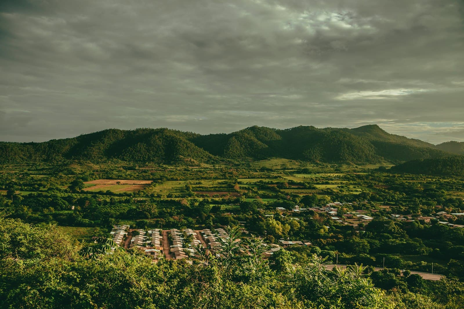 Homes spread across a green valley below forested hills in Honduras