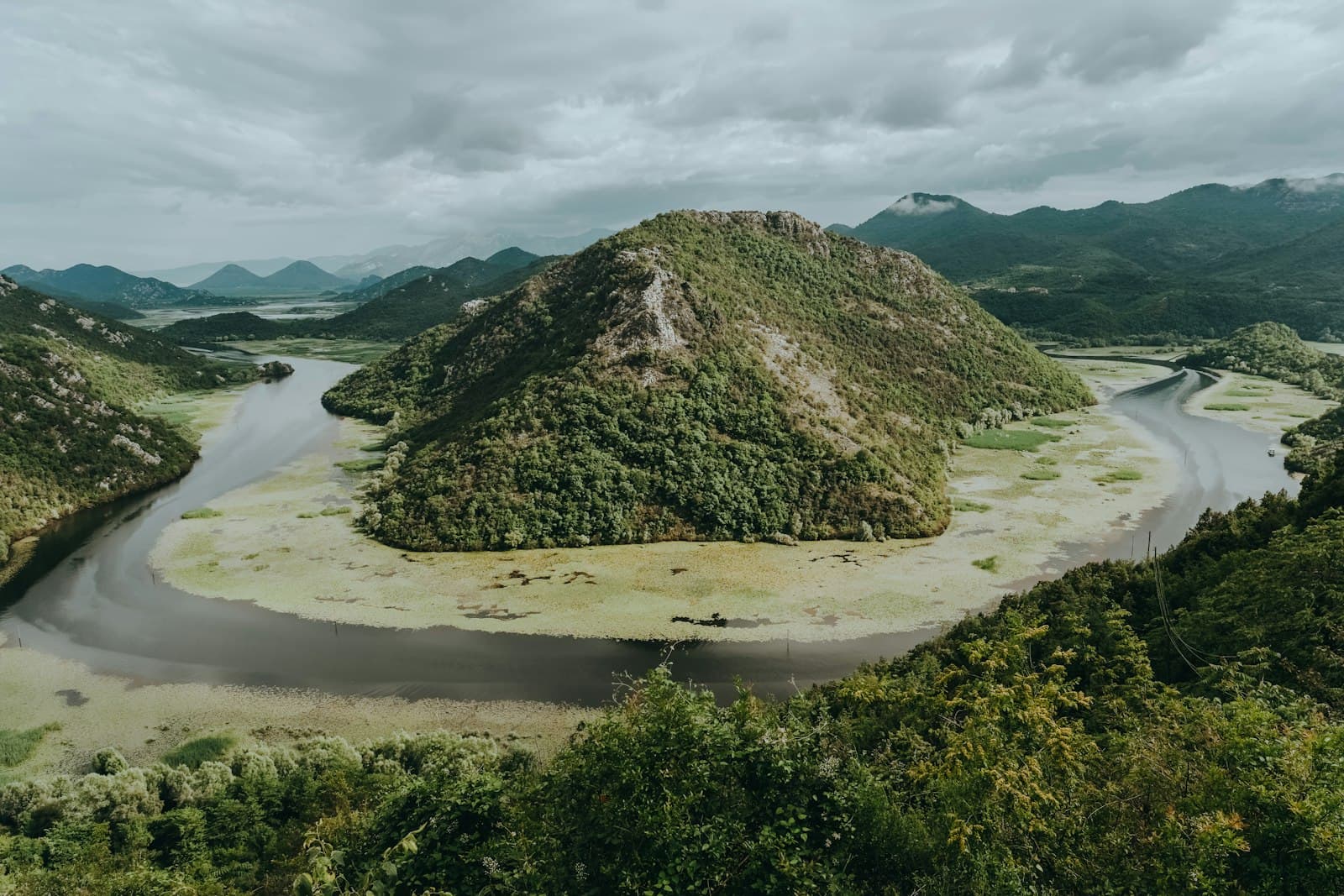 The Crnojević River bending around a green hill near Lake Skadar