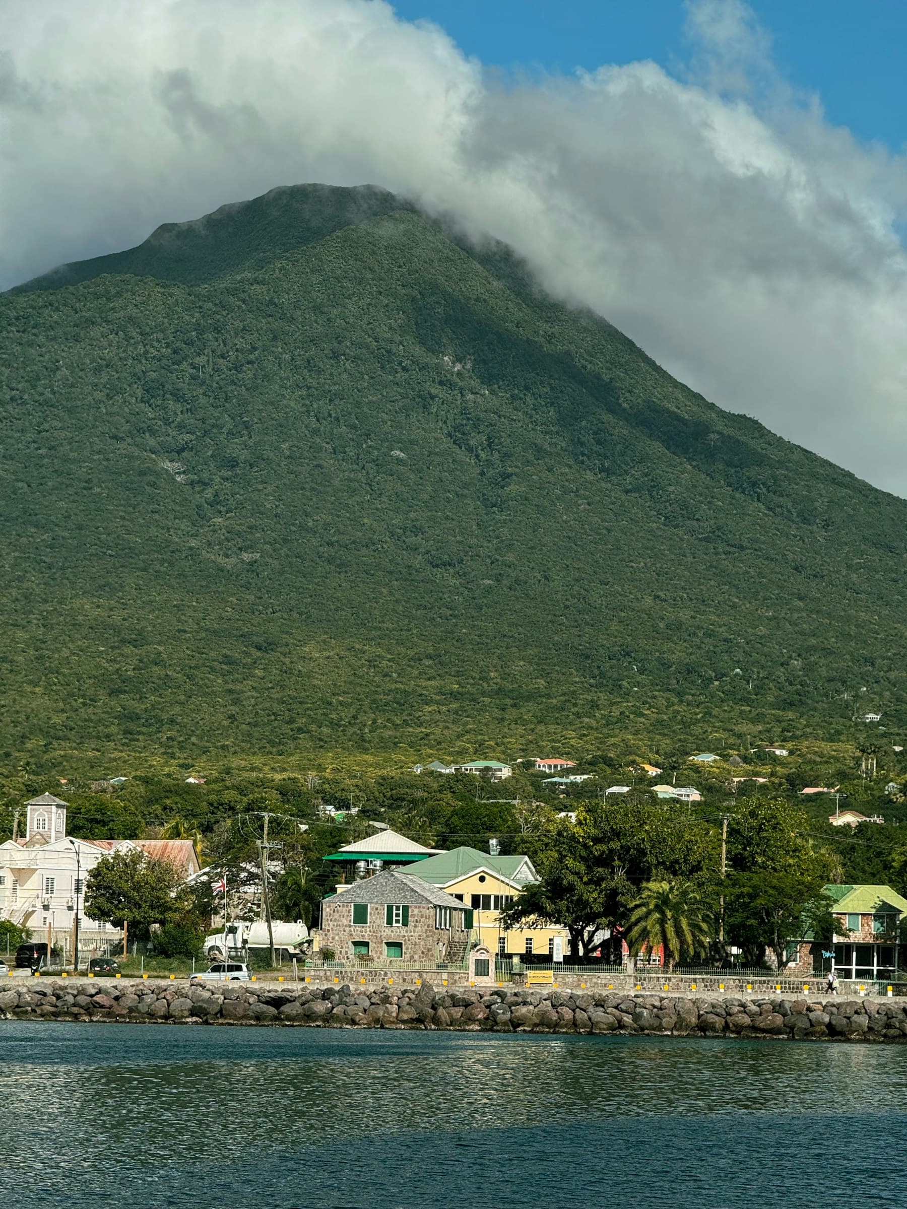 Charlestown waterfront on Nevis with Nevis Peak rising behind it under cloud