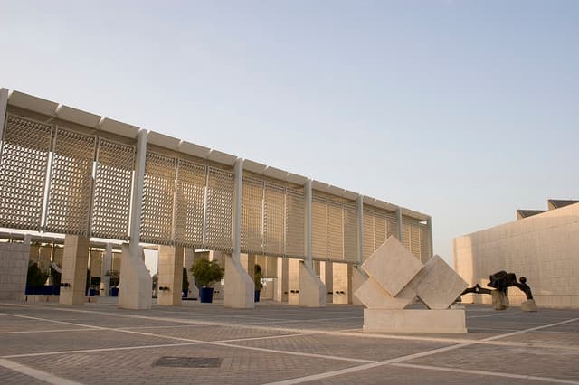 The latticed facade and stone courtyard of the Bahrain National Museum in Manama